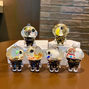 Set di portachiavi con astronauta galleggiante e sabbie mobili liquide in nero e oro
