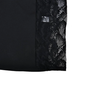 Gros plan détaillé montrant l'élégant patchwork de dentelle et le tissu noir de la robe