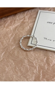 Detail of s925 sterling silver beaded ring with adjustable open band on paper background