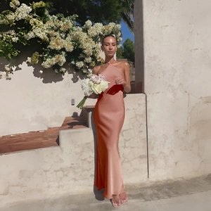 Detail of elegant backless halter neck satin dress in champagne gold with silky texture
