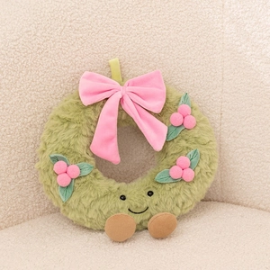 Detail of Christmas plush wreath with a pink bow, cute embroidered face and brown feet