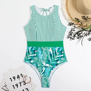 Flat lay of a striped and tropical leaf print one-piece swimsuit with lace-up back detail