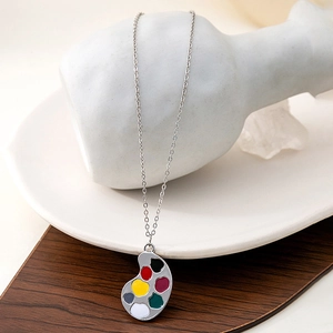 Artistic silver paintbrush palette necklace featuring colorful enamel droplets detail