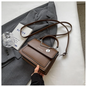Detail of a brown leather handbag with silver chain and Fashion & Bags inscription