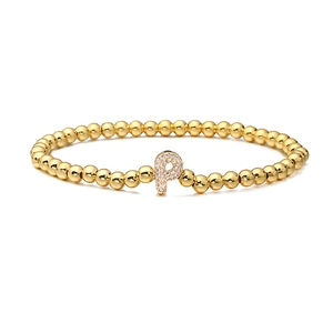 Macro view of gold beaded elastic bracelet featuring a sparkling micro-pave letter P charm