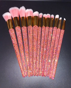 Macro view of 12-piece professional makeup brushes with glittering orange-pink rhinestones