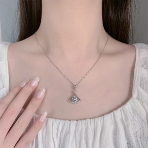 Close-up of 2 carat round zircon pendant necklace worn by a model in soft lighting
