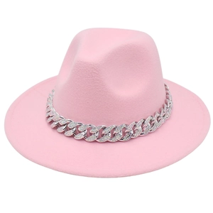 Detail of pink fedora hat featuring a chunky silver Cuban chain with sparkling rhinestones