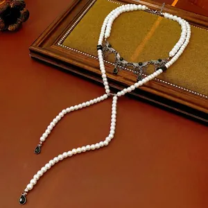 Double-layered pearl necklace with silver butterfly wing and black waterdrop pendant