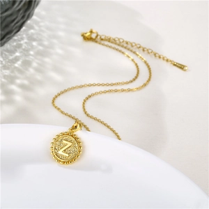 Detailed view of golden round pendant featuring letter Z on fine stainless steel chain