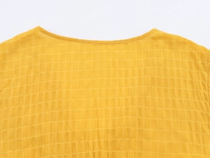 Dettaglio del tessuto seersucker giallo con sottili motivi a quadretti strutturati
