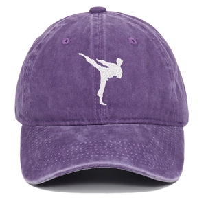Detail of purple washed cotton baseball cap featuring white martial arts silhouette embroidery
