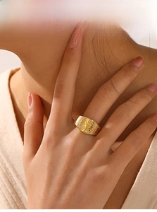 Macro detail of 18k gold plated stainless steel signet ring with tree of life relief