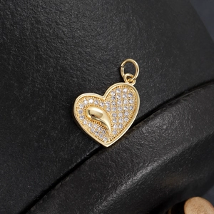 Macro detail of 18K gold plated heart pendant with micro-paved cubic zirconia stones