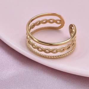 Macro detail of gold triple-layered ring featuring infinity symbol and rope texture