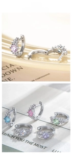 Macro shot of silver zircon earrings in five colors on a ceramic display tray