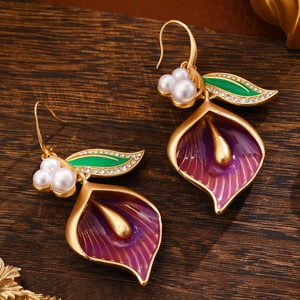 Elegant purple enamel calla lily earrings with white pearls on a vintage wood background