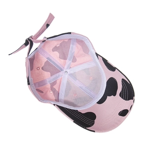 Detail view of pink cow print baseball cap interior with cotton sweatband and strap