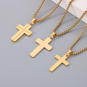 Macro view of three gold stainless steel cross pendants with unique geometric textures