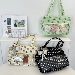 Detailed view of polka dot tote bags with transparent windows and plush toys inside