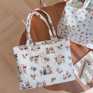 Detail of quilted tote bag featuring retro bear print and soft cotton padding textures