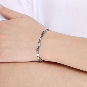 Silver stainless steel oval link chain bracelet worn on wrist with lobster clasp closure