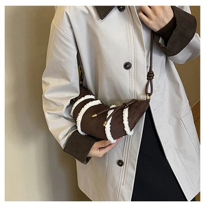 Detailansicht einer Vintage dunkelbraunen Wildleder Croissant Tasche mit Pelzstreifen