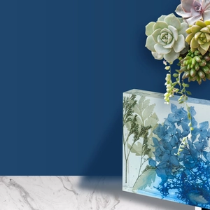 Detailed view of dried blue flowers preserved in thick rectangular clear resin mold