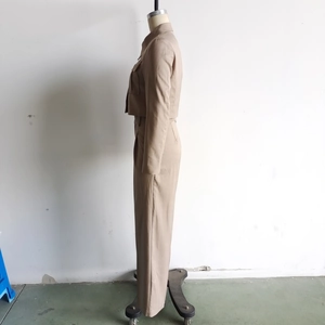 Side view of beige two-piece jacket and trousers set on a mannequin with pocket details