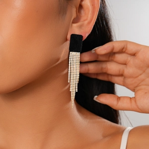 Gros plan de boucles d'oreilles carrées floquées noires avec de longs glands en strass