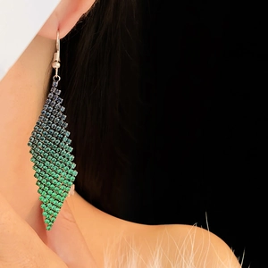 Gros plan sur un mannequin portant des boucles d'oreilles losange à franges
