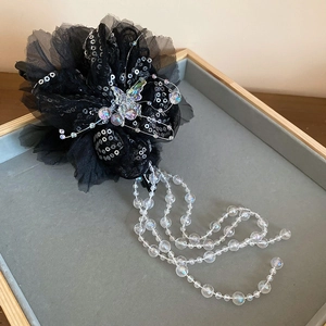 Detail der schwarzen Haarklammer aus Organza mit Pailletten-Schmetterling und langen Perlenketten