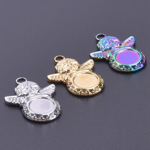 Tres colgantes de ángel para bricolaje en oro, plata e irisados sobre un fondo gris oscuro