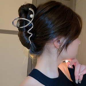 Silver wavy metal hair claw clip with pearl on model for elegant updo styling