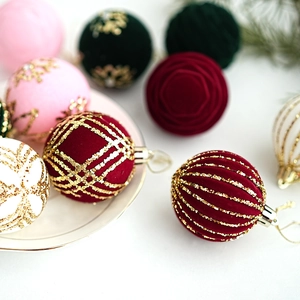 Detail of velvet Christmas balls with gold glitter patterns and hanging strings