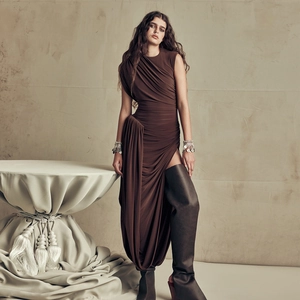 Detail of brown sleeveless dress with high slit and elegant draped fabric texture
