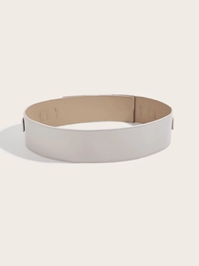 Detail shot of a wide white faux leather corset belt for dresses and winter coats