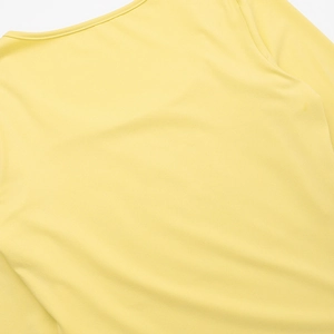 Detail of a bright yellow knit top showing the fine texture and round neckline finish