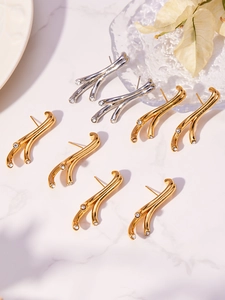 Vue détaillée de boucles d'oreilles en branche avec micro-zircons sur fond de marbre chic
