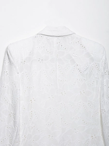 Gros plan sur la broderie de dentelle florale blanche et le motif ajouré au dos du blazer