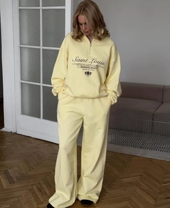 Detail of light yellow two-piece tracksuit with zip-up sweatshirt and wide-leg trousers