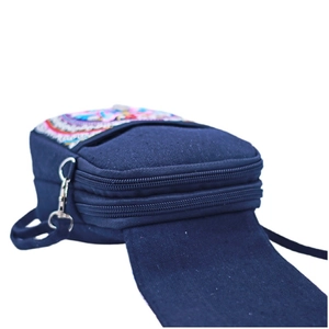 Detail view of ethnic embroidery on navy blue canvas bag with double zipper layers