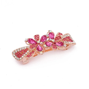 Detailed macro of rose gold bow hair clip with pink rhinestones and flower crystals