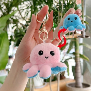 Detail of reversible octopus plush keychain showing pink smile and blue sad faces