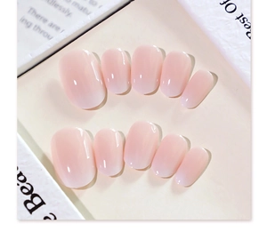 Close-up of pink gradient short round press-on nails set on a decorative display