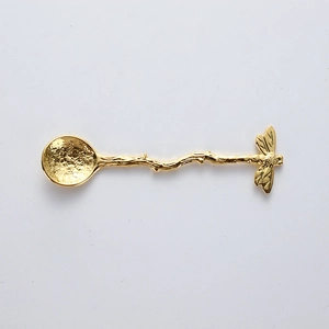 Golden vintage branch spoon with textured hammered bowl and bee decoration