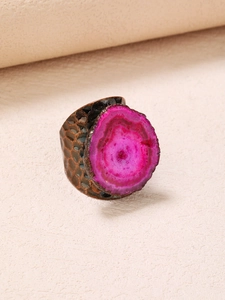Detail of vintage wide ring featuring a pink quartz stone and textured antique bronze band