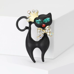Detail of black enamel cat brooch with gold crown, bow and sparkling crystal accents