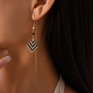 Elegant gold drop earrings with geometric diamond pendants and black and white zircon