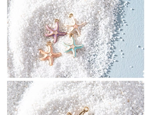Colorful starfish alloy charms for DIY jewelry making displayed on white sand beach